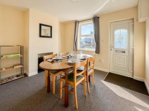 a dining room with a wooden table and chairs at Billada Cottage in Firsby