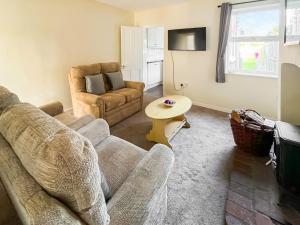 a living room with a couch and a table at Billada Cottage in Firsby +10 photos