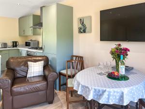 a small kitchen with a table with a bottle of wine at Ridge View Lodge - Uk49924 in Dumfries +9 photos