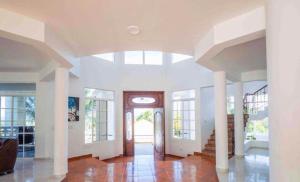 a living room with a vaulted ceiling and a door at villa la dueña in San Felipe de Puerto Plata