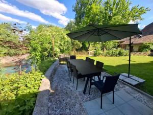 a table and chairs with an umbrella in a yard at River House Mojstrana in Mojstrana
