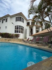 a house and a swimming pool in front of a house at villa la dueña in San Felipe de Puerto Plata