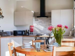 a kitchen with a wooden table with a vase of flowers at One The Old Stables in Knitsley