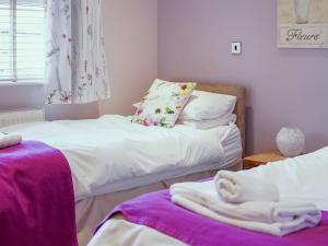 two beds in a room with towels on them at One The Old Stables in Knitsley
