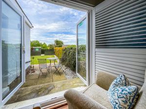 a room with a balcony with a couch and a table at Taigh Beag in Stranraer