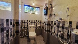 ein Badezimmer mit Toilette und Dusche in der Unterkunft Sandy Beach Hotel in Arugam Bay