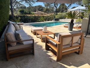 a group of chairs and tables next to a pool at Villa "LES ALIZES" Côté jardin - Bord de mer in Saint-Raphaël