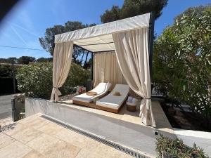a gazebo with a bed and a canopy at Villa "LES ALIZES" Côté jardin - Bord de mer in Saint-Raphaël