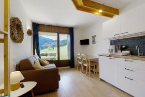 a kitchen and living room with a couch and a table at Les Cimes - La Canopée in Gresse-en-Vercors