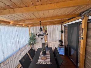 a porch with a table and chairs and a television at Mobile home FJAKA in Biograd na Moru