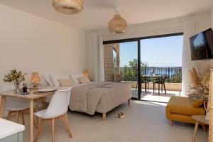 a white bedroom with a bed and a table and chairs at Casa Marina Cargèse in Cargèse