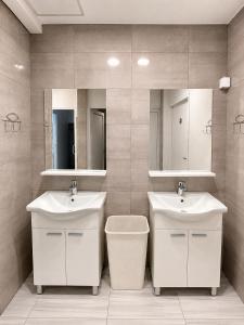 a bathroom with two sinks and a mirror at Hostel Suzzzy in Novska