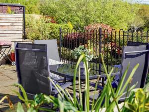 two chairs and a table with a tv in a garden at Two The Old Stables in Knitsley