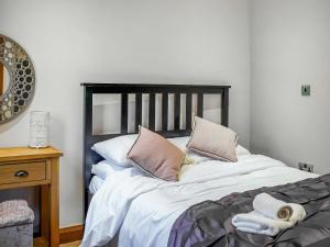 a bedroom with a large bed with two pillows at Two The Old Stables in Knitsley