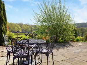 a table and four chairs sitting around a patio at Three The Old Stables in Knitsley +7 photos