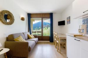 a living room with a couch and a kitchen with a table at Les Cimes - La Canopée in Gresse-en-Vercors