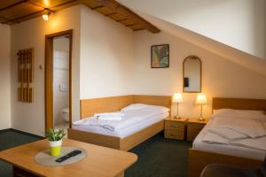 a bedroom with two beds and a table and a mirror at Hotel Kanarek in Prague +46 photos