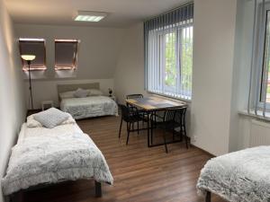 a room with two beds and a table with chairs at City Center Szczytno III in Szczytno