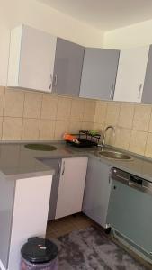 a kitchen with white cabinets and a sink at Apartman Dream in Foča