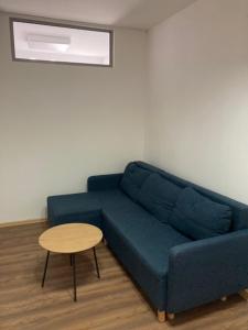 a blue couch in a living room with a table at City Center Szczytno III in Szczytno