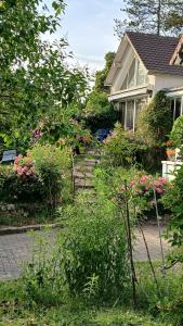 a house with a garden with pink flowers at Le chant des roses in Giverny