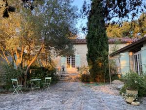 a house with chairs and a table in front of it at La Bordeneuve - Chambre d'hôtes in Auch