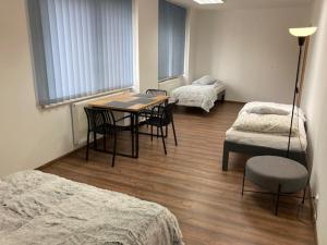a room with three beds and a table and chairs at City Center Szczytno III in Szczytno