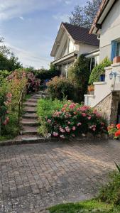 a set of stairs leading to a house with flowers at Le chant des roses in Giverny