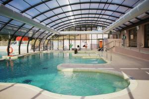 a swimming pool in a building with a glass ceiling at Domaine des Gueules Cassees in La Valette-du-Var