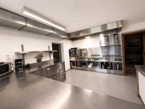 a large kitchen with stainless steel counters and appliances at Demlhof, Gästehaus in Finkenberg +6 photos