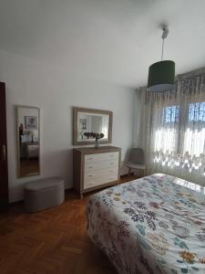 a bedroom with a bed and a dresser and a mirror at La Royana in Vinuesa