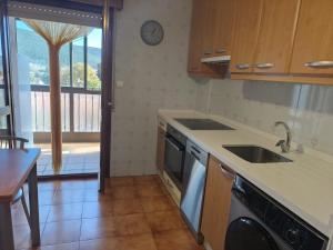 a kitchen with a sink and a dishwasher at La Royana in Vinuesa