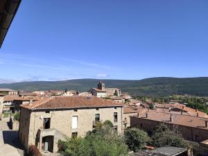 a view of a town with buildings and mountains at La Royana in Vinuesa