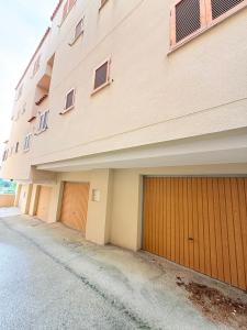 a building with two garage doors next to a street at Bungalow Esqui II Ref 076 in La Virgen de la Vega