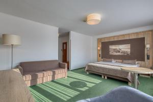 a room with a bed and a couch and a table at Hotel Unitral SPA w Mielnie in Mielno +72 photos