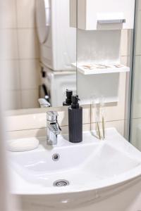a bathroom with a white sink and a mirror at Apartman Centar in Teslić +24 photos