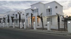 a white house with palm trees in front of it at Astara Villa Boutique Hotel in Astara