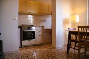 a kitchen with a stove and a table with a lamp at CASA IUCCI Langhe Monferrato in Canelli +4 photos