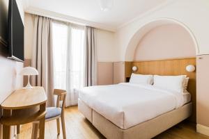 a hotel room with a bed and a desk at Hôtel Oratio in Paris