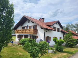 a white house with a balcony on top of it at Ferienwohnung Czanderl in Dießen am Ammersee