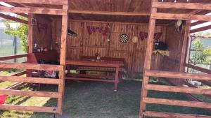 a wooden cabin with a table and a bed in it at Cazare Adda Body in Corbu