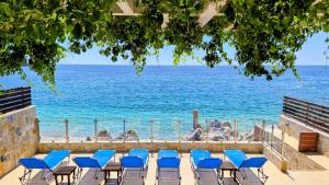 a group of chairs on a patio overlooking the ocean at Mare Beachfront Rooms Himare in Himare