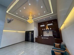 a lobby with a reception desk and a chandelier at Hotel Skyboat Inn in Nashik
