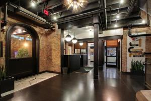 a lobby with a black door and a brick wall at Hotel Hive in Washington, D.C.
