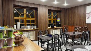 a restaurant with wooden walls and tables and chairs at AIRIS Residence in Almaty