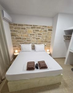a bedroom with a large bed with a stone wall at Lithos Home Agia Galini in Agia Galini