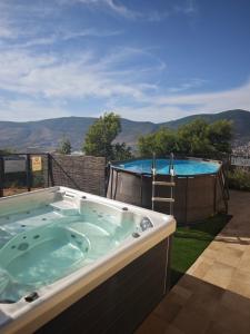 a jacuzzi tub with a view of a pool at michal Cozy Garden Unit & Jacuzzi in Kammon