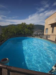 a large blue swimming pool in front of a building at michal Cozy Garden Unit & Jacuzzi in Kammon