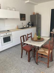 a kitchen with a table and chairs and a refrigerator at Maralocquet in Barbezieux-Saint-Hilaire