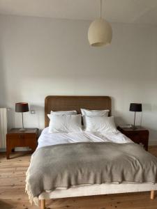 a bedroom with a large bed with white sheets and pillows at Maralocquet in Barbezieux-Saint-Hilaire